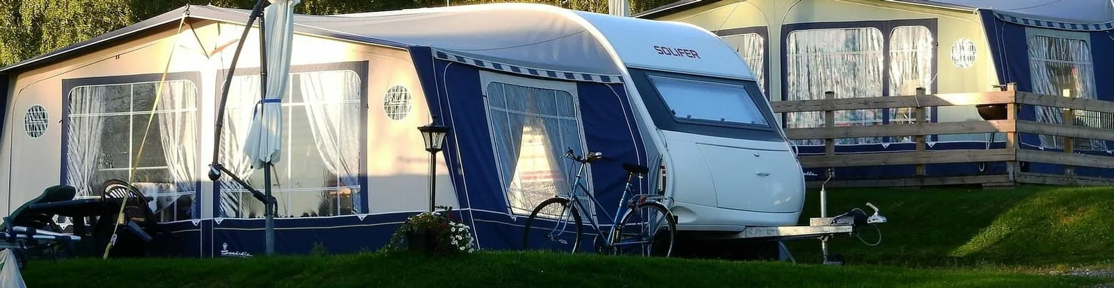 A caravan pitched in the sunshine at Chertsey Caravan Park